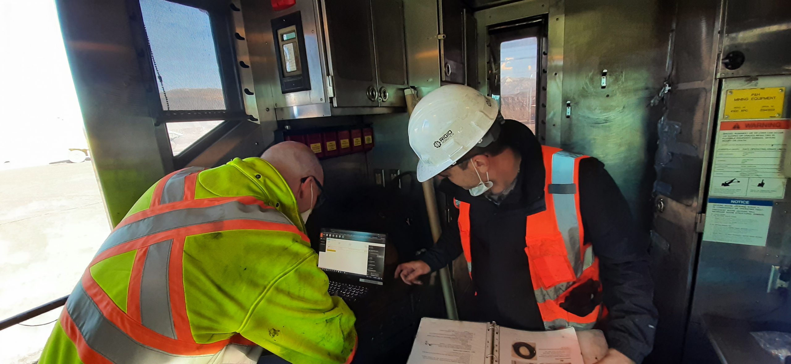 RIGID staff checking equipment with a laptop inside a shovel