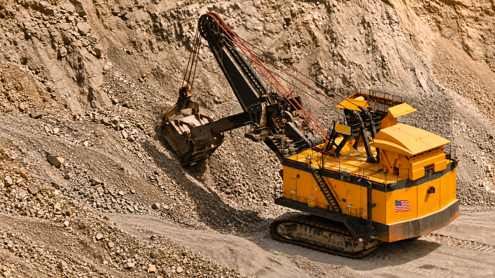 Yellow rope shovel digging against a rocky mine face